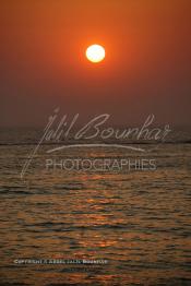 Image du Maroc Professionnelle de  Un magnifique coucher de soleil sur la plage de Souiria Lekdima à 30 Km au sud de Safi, dans cette splendide région du Maroc sur l'océan atlantique. De nombreux européens profitent des joies de la mer sur cette plage un peu désertée par les marocains, le 14 Août 2003. (Photo / Abdeljalil Bounhar)